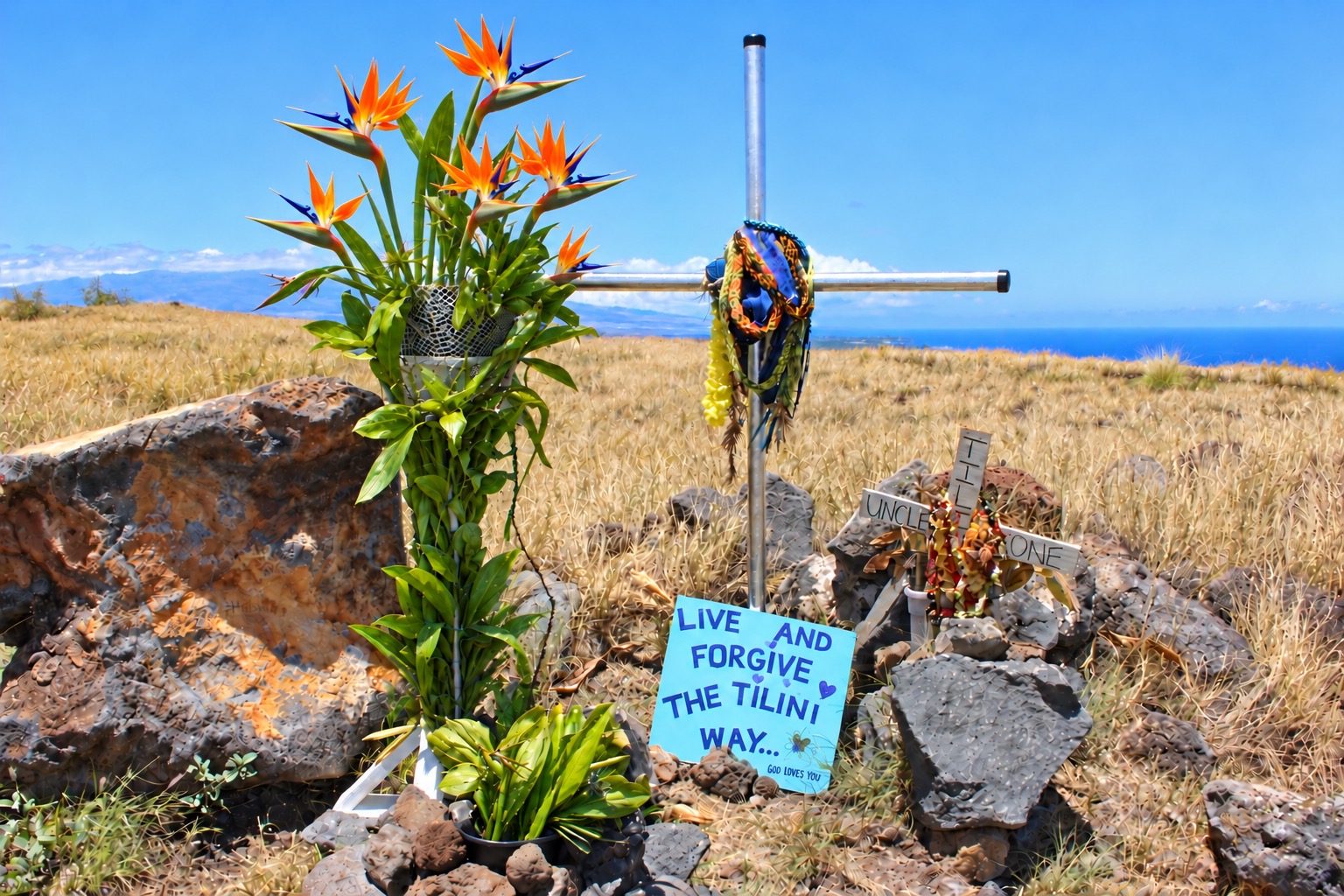 Roadside memorial cross with flowers overlooking the ocean